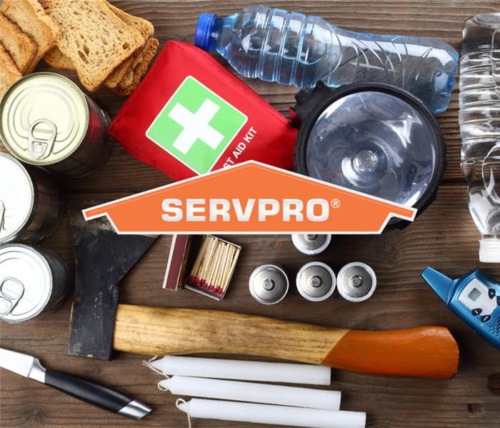Photo taken from above looking down on emergency supplies on a table. Orange SERVPRO Logo in center of photo