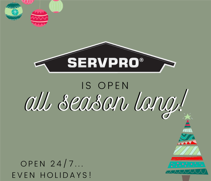Green background with words announcing SERVPRO is open 24/7/365. Christmas tree & ornaments in opposite corners